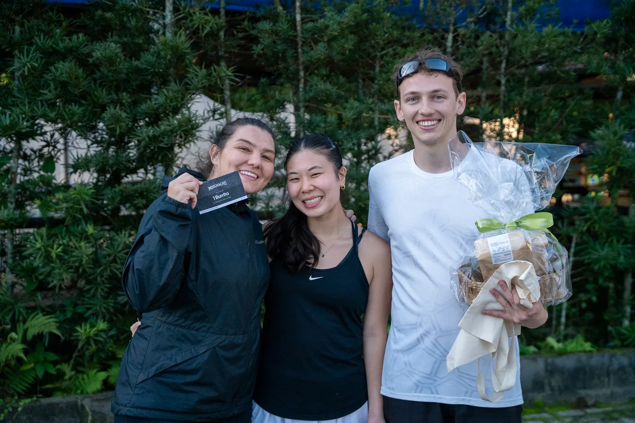 Tres participantes posan con un regalo en el encuentro.